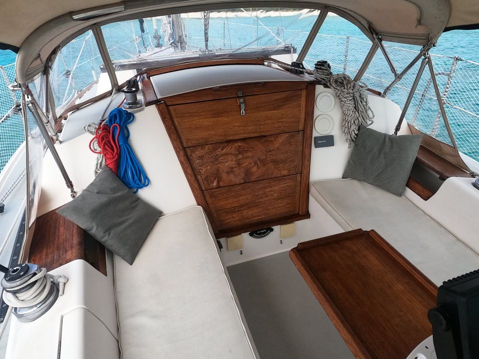 Cockpit de voilier avec coussins et cordages colorés.