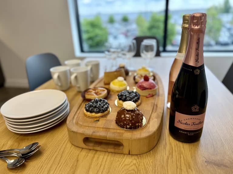 Desserts et champagne sur table bois, intérieur moderne.